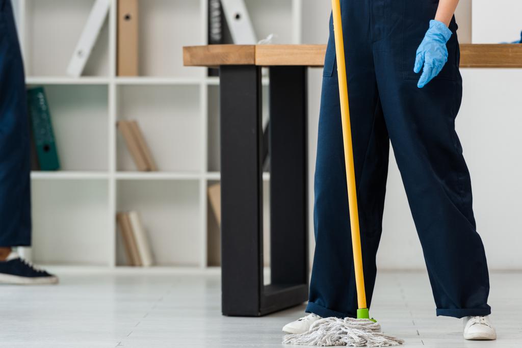 Vista recortada del limpiador en guante de goma lavando piso con fregona en la oficina
  - Foto, Imagen