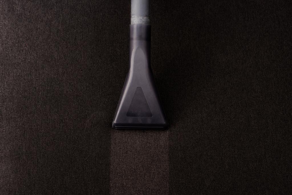 Vista superior del cepillo de aspiradora en la tapicería marrón del sofá
  - Foto, imagen
