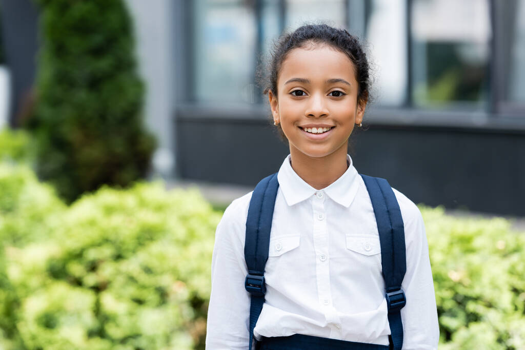 smiling african american schoolgirl with backpack outdoors - Photo, Image