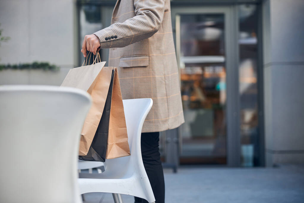 Стильний молодий чоловік з покупками, що стоять на вулиці
 - Фото, зображення