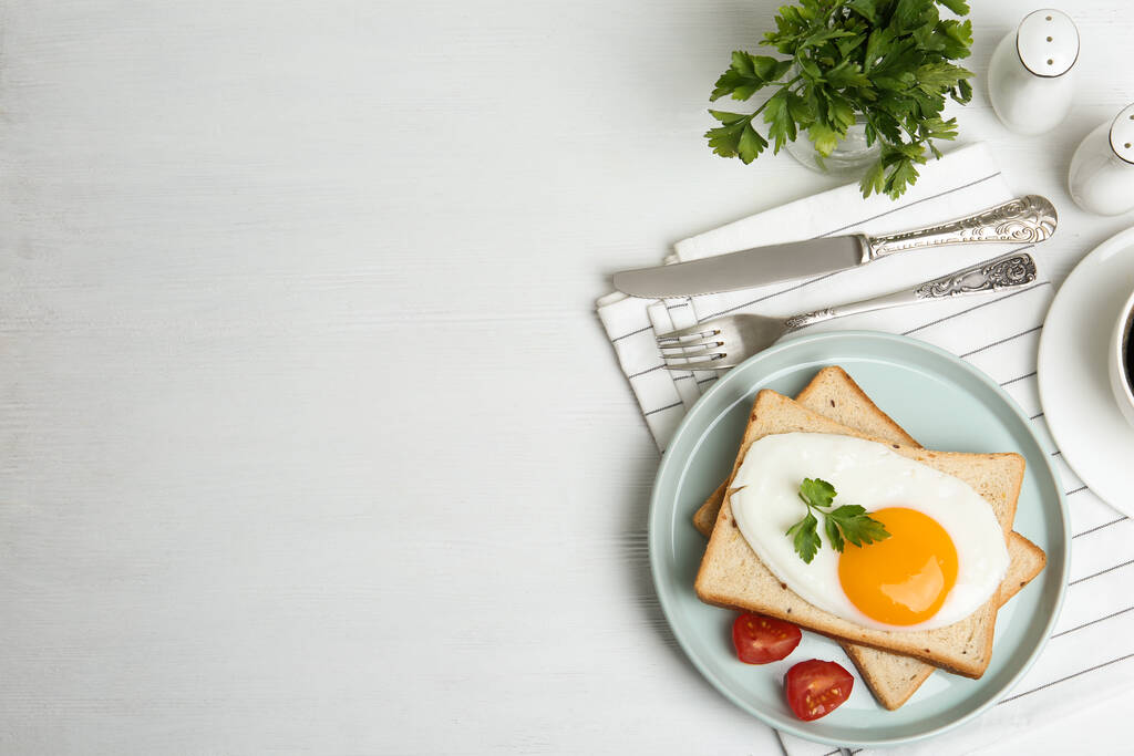 Вкусное жареное яйцо с хлебом и помидорами на белом деревянном столе, плоская кладка. Пространство для текста
 - Фото, изображение
