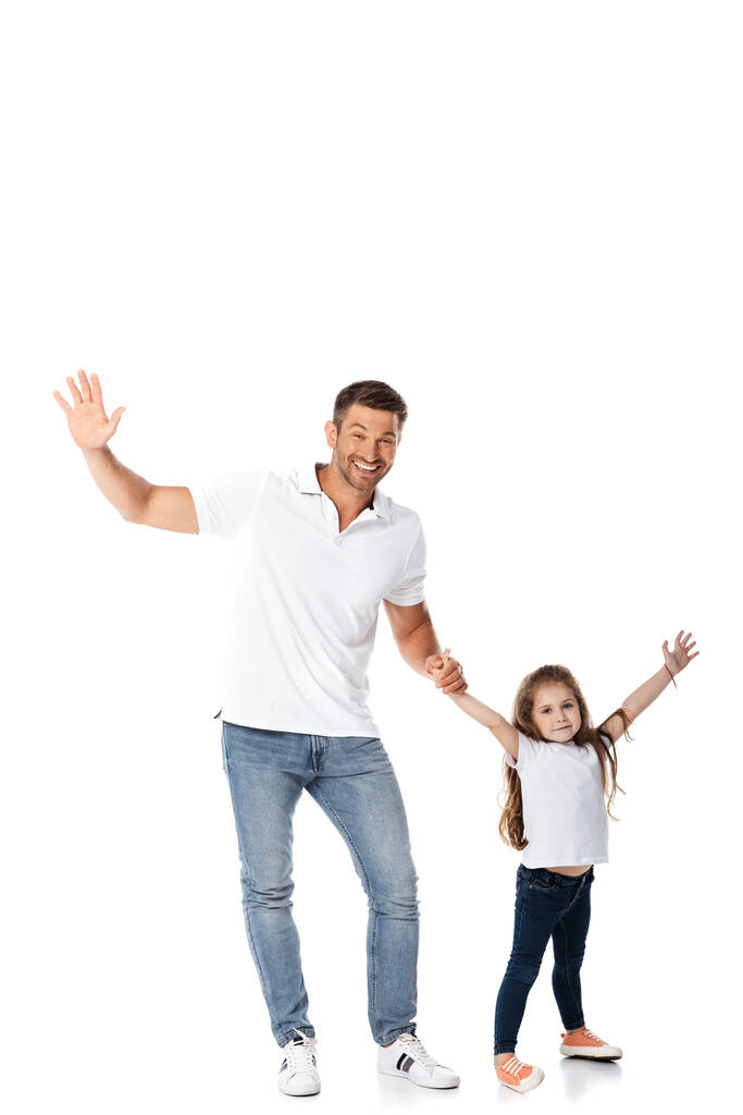Χαρούμενος πατέρας και κόρη που κρατιούνται χέρι-χέρι στα λευκά  - Φωτογραφία, εικόνα