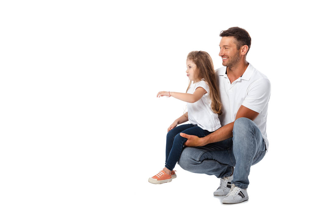 χαριτωμένη κόρη κάθεται σε ευτυχισμένο πατέρα απομονωμένη σε λευκό  - Φωτογραφία, εικόνα