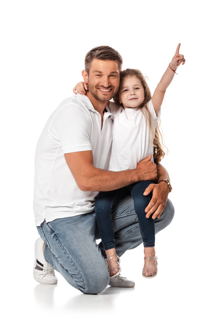 szczęśliwa córka siedzi na ojcu i wskazuje palcem na białym  - Zdjęcie, obraz