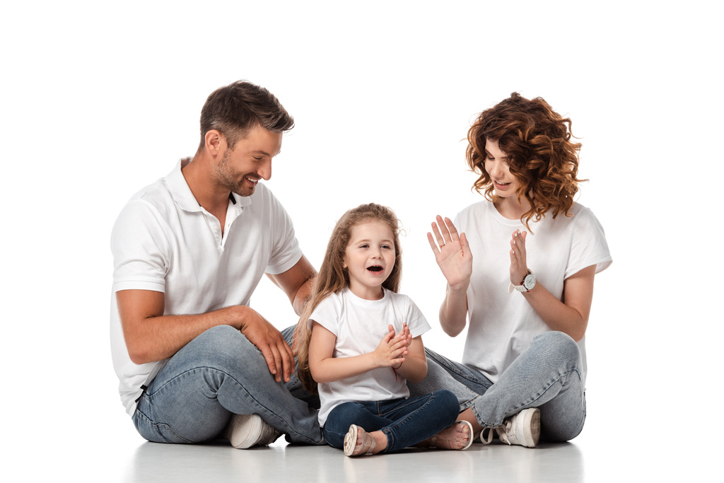happy father and mother looking at cute daughter clapping hands on white  - Photo, Image