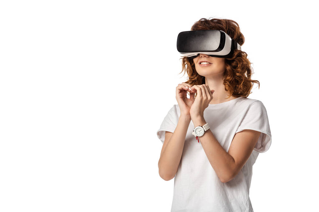 curly woman in virtual reality headset showing heart with hands isolated on white  - Photo, Image