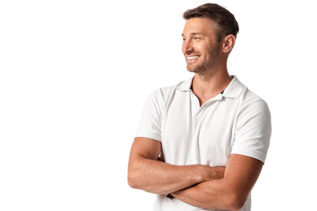 glücklicher Mann im weißen T-Shirt, der mit verschränkten Armen auf weißem Hintergrund steht  - Foto, Bild