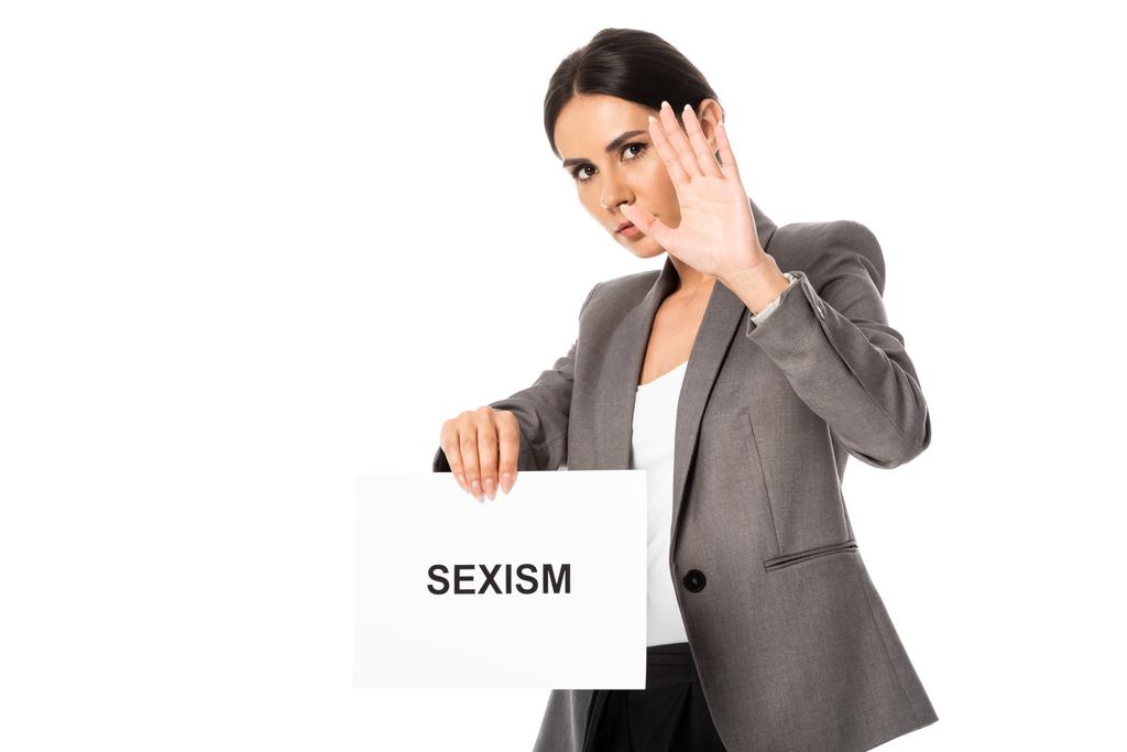 Geschäftsfrau zeigt Stoppschild und hält Plakat mit Sexismus-Schriftzug in der Hand - Foto, Bild