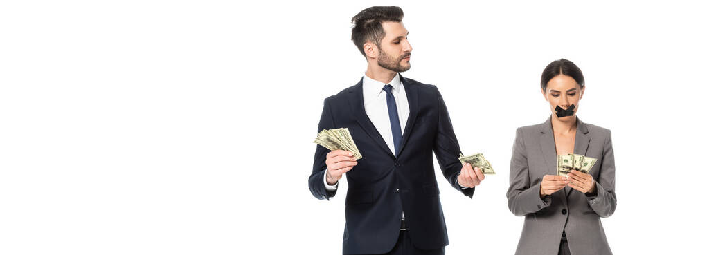 récolte horizontale d'homme d'affaires tenant des dollars et regardant femme d'affaires avec du ruban adhésif sur la bouche isolé sur blanc - Photo, image