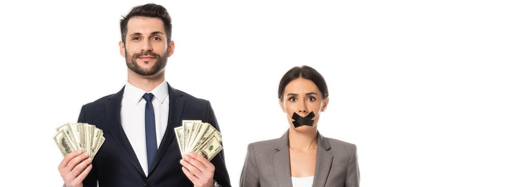 horizontales Bild eines Geschäftsmannes, der Dollars in der Nähe einer Geschäftsfrau hält, mit Klebeband auf dem Mund, isoliert auf weißem Grund - Foto, Bild