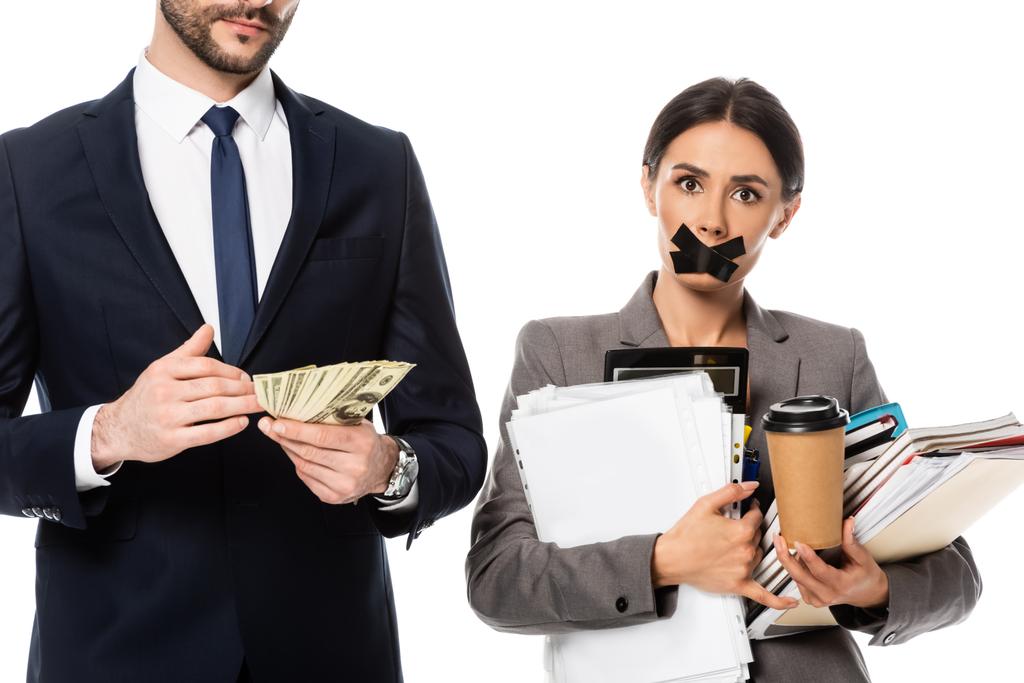 bärtiger Geschäftsmann hält Dollars in der Nähe von Geschäftsfrau mit Klebeband auf Mund isoliert auf weißem, Sexismus-Konzept  - Foto, Bild