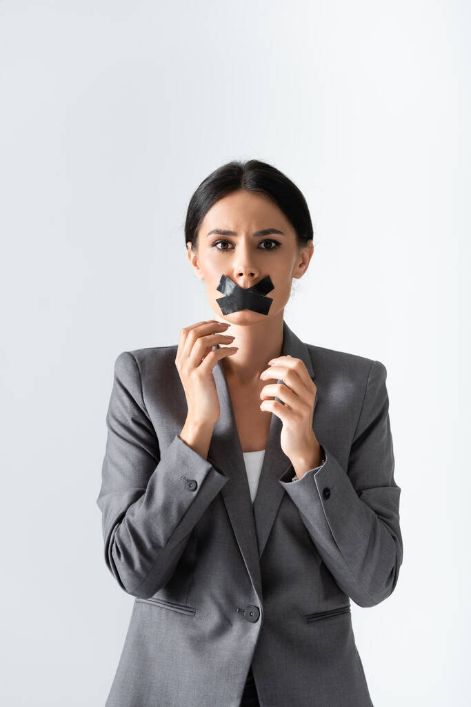 empresária com fita adesiva na boca olhando para câmera isolada no branco, conceito de desigualdade de gênero
  - Foto, Imagem