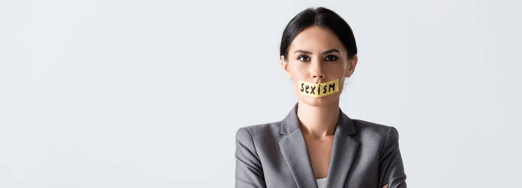 encabezado del sitio web de la mujer de negocios con letras de sexismo en cinta adhesiva aislada en blanco
  - Foto, imagen