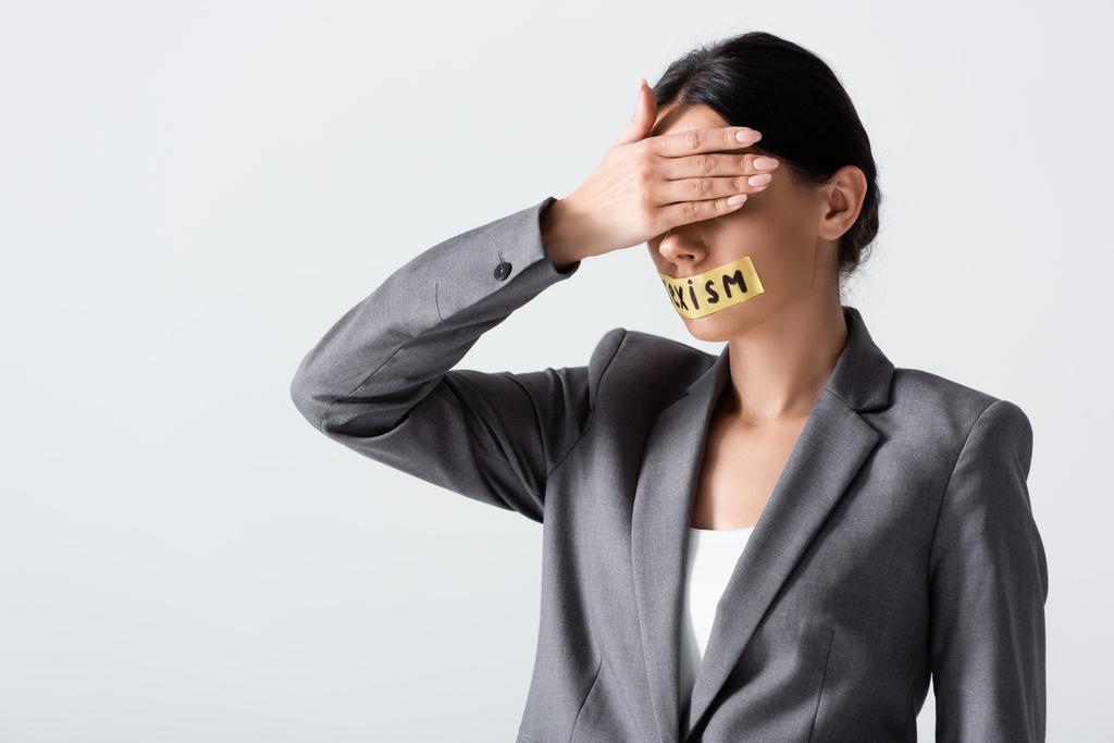 zakenvrouw met seksisme belettering op scotch tape bedekking ogen geïsoleerd op wit  - Foto, afbeelding