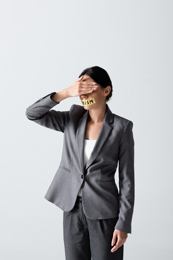 businesswoman with sexism lettering on duct tape covering eyes isolated on white  - Photo, Image