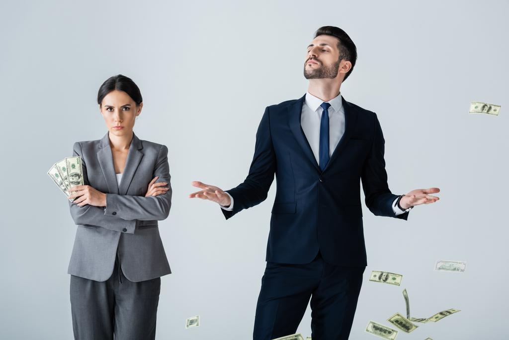 приваблива бізнес-леді тримає долари біля зарозумілого бізнесмена, що стоїть на білому
 - Фото, зображення