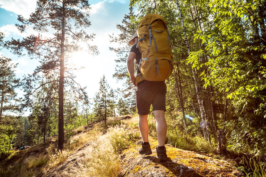 Homme voyage en solo avec un sac à dos lumineux randonnée dans les montagnes nordiques active mode de vie sain aventure. Concept de voyage et vacances - Photo, image