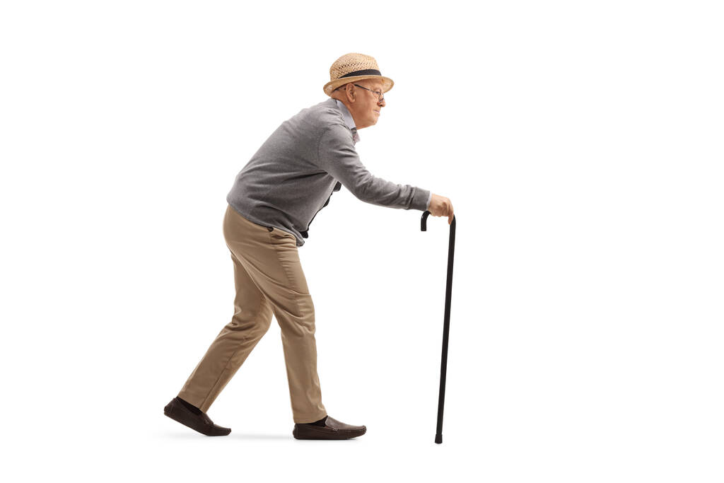Foto de perfil completo de un anciano caminando con un bastón aislado sobre fondo blanco
 - Foto, imagen