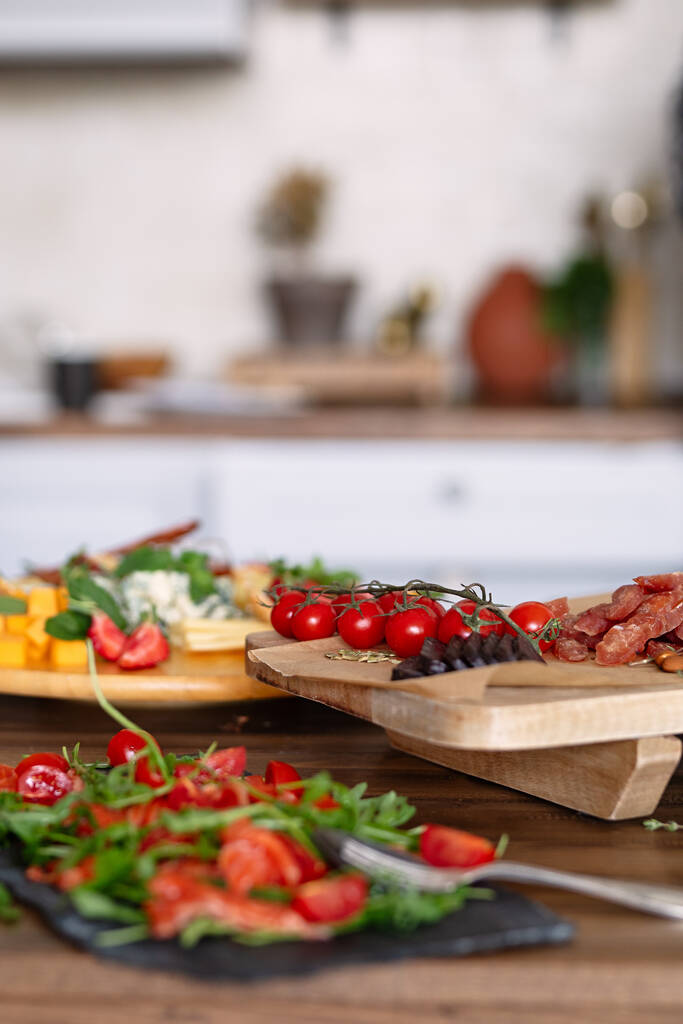 tomates cerises reposent sur le panneau en bois, foyer sélectif, nourriture et objets sur le fond, - Photo, image