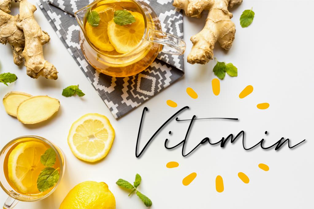 vista superior del té caliente en la servilleta cerca de la raíz de jengibre, limón y menta sobre fondo blanco, ilustración de vitaminas
 - Foto, imagen