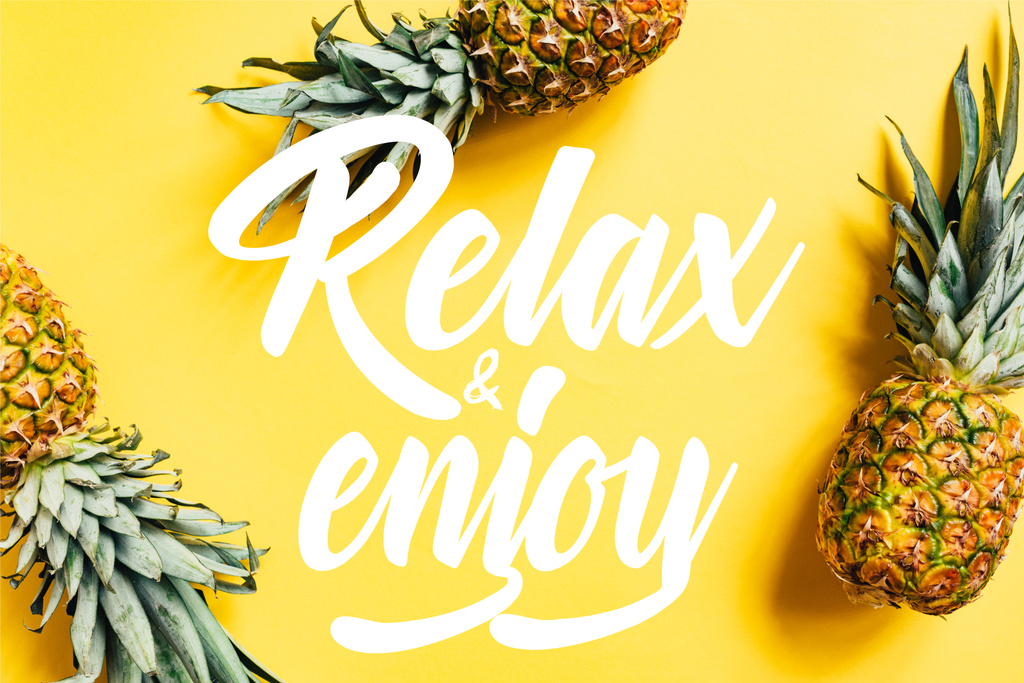 top view of fresh tasty pineapples on yellow background with relax and enjoy illustration - Photo, Image