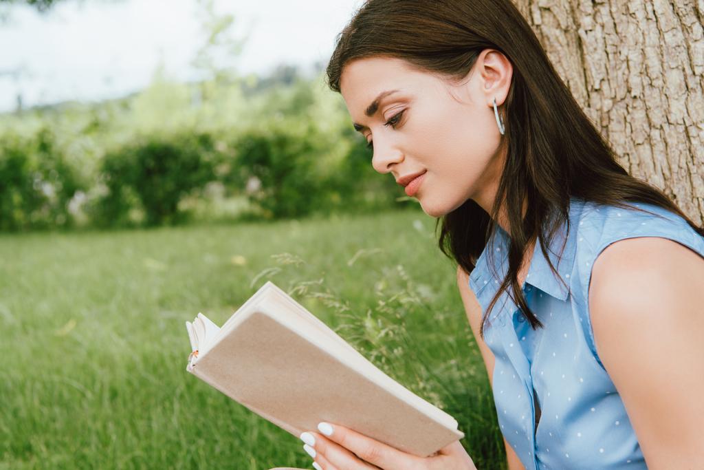 belle jeune femme lecture livre à l'extérieur  - Photo, image