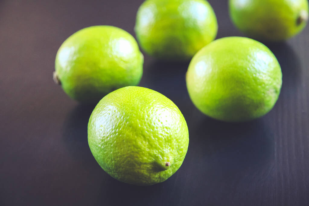 Grupa świeżych limonek organicznych na czarnym tle stołu - Zdjęcie, obraz