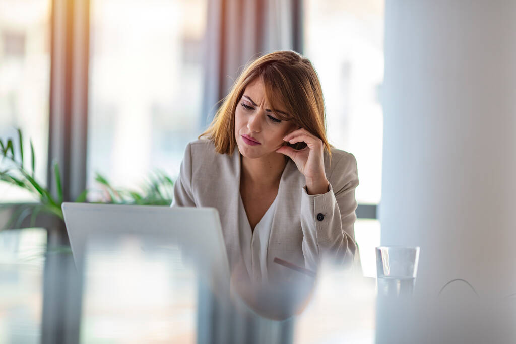 ノートパソコンでオフィスで問題解決を考えながら退屈を離れて見て思考ビジネスの女性,深刻な日照りの従業員は退屈な仕事についてのやる気のない仕事で新しいアイデアを検索します - 写真・画像