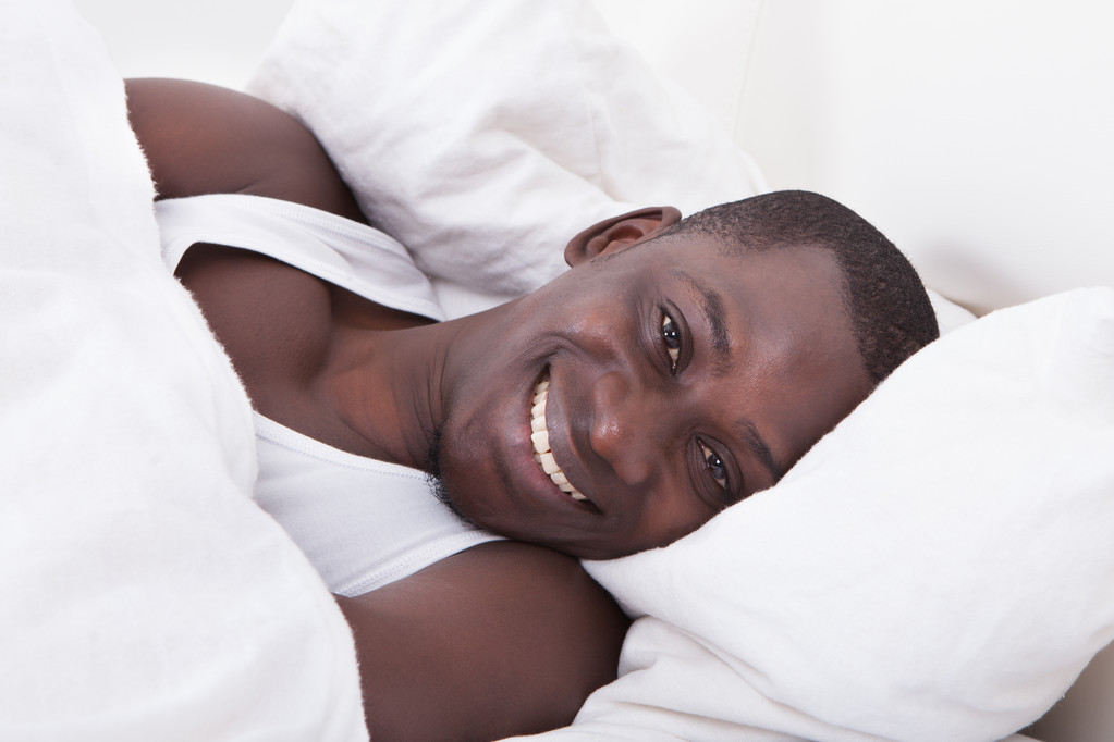 afrikai férfi ágyon - Fotó, kép