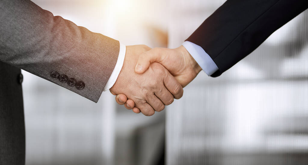 ビジネスの人々立って、日当たりの良いオフィスで握手を閉じる。握手とマーケティング - 写真・画像