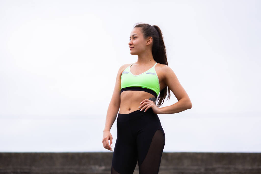 Schattig meisje fitness instructeur poseren op online workout buiten, fotografie voor blog of advertentie van sport en gezonde levensstijl - Foto, afbeelding