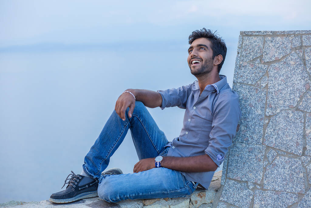 Homem sorrindo olhando para o céu azul tomando respiração profunda celebrando a liberdade enquanto sentado em uma ponte de parede de concreto acima do mar. Pessoa positiva, conceito de paz mental. livre feliz cara aproveitando por do sol
 - Foto, Imagem