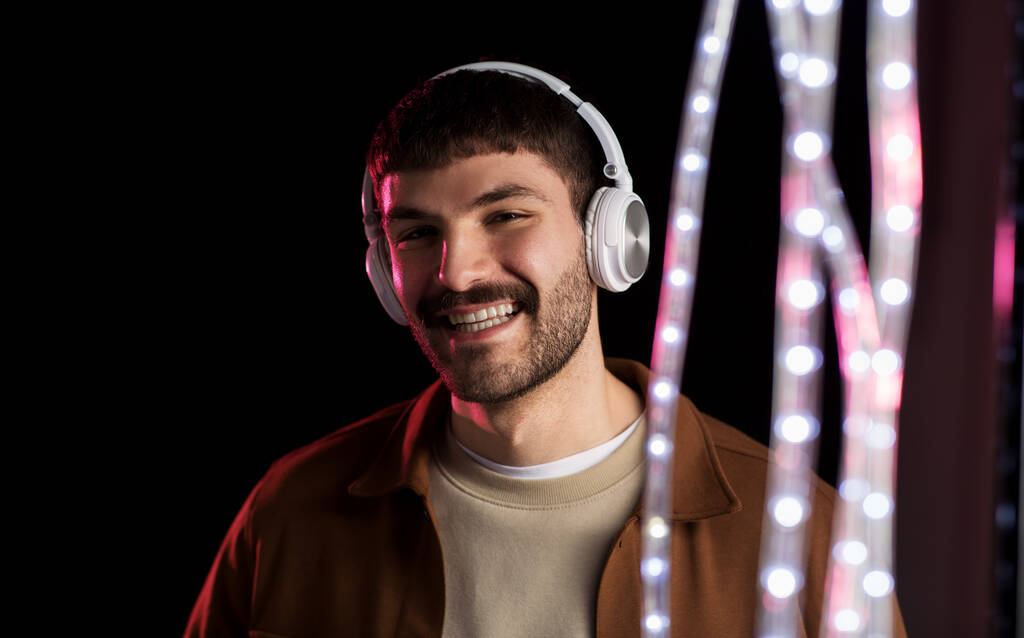 homem em fones de ouvido sobre luzes de néon do clube noturno
 - Foto, Imagem