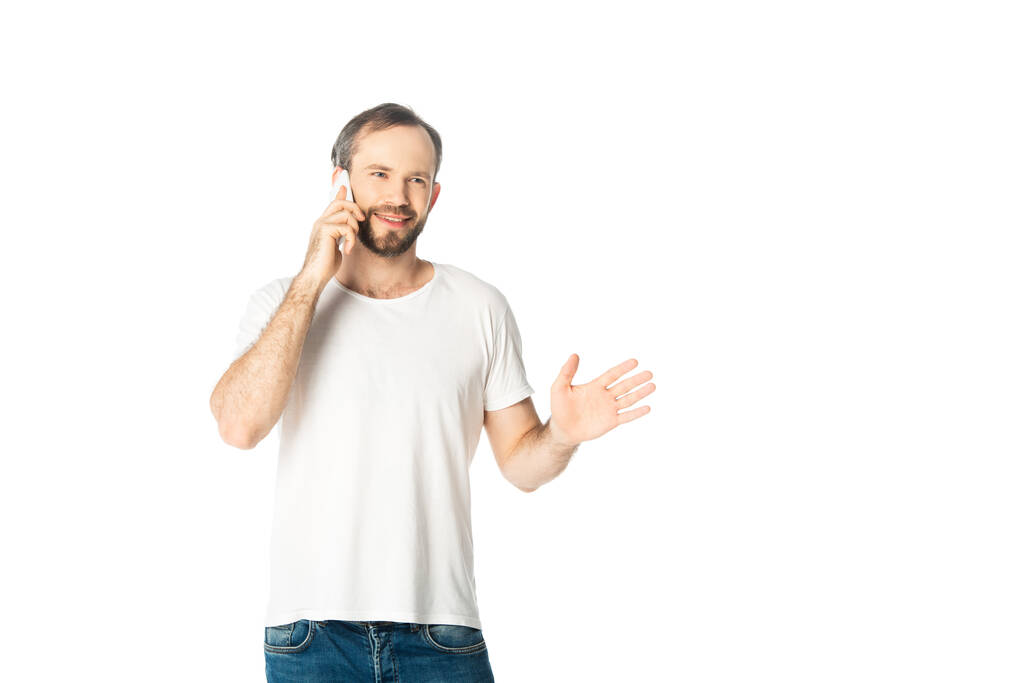 smiling man talking on smartphone and gesturing isolated on white - Photo, Image