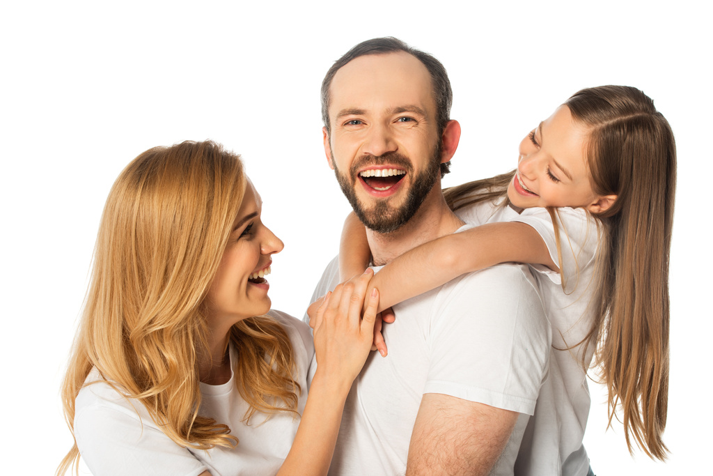 glückliche Familie in weißen T-Shirts, die sich isoliert auf Weiß umarmen - Foto, Bild