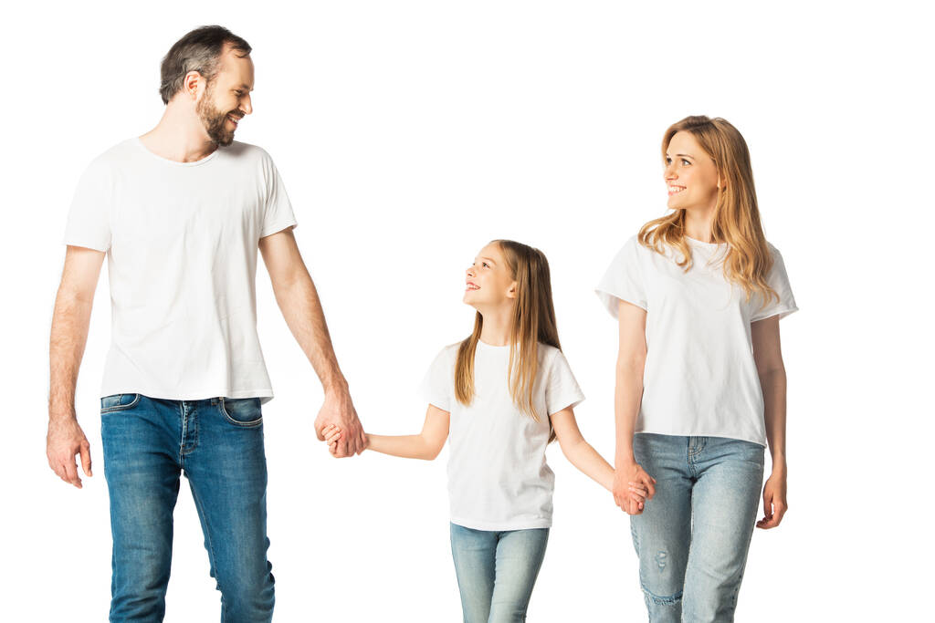 heureux casual famille tenant la main tout en marchant isolé sur blanc - Photo, image