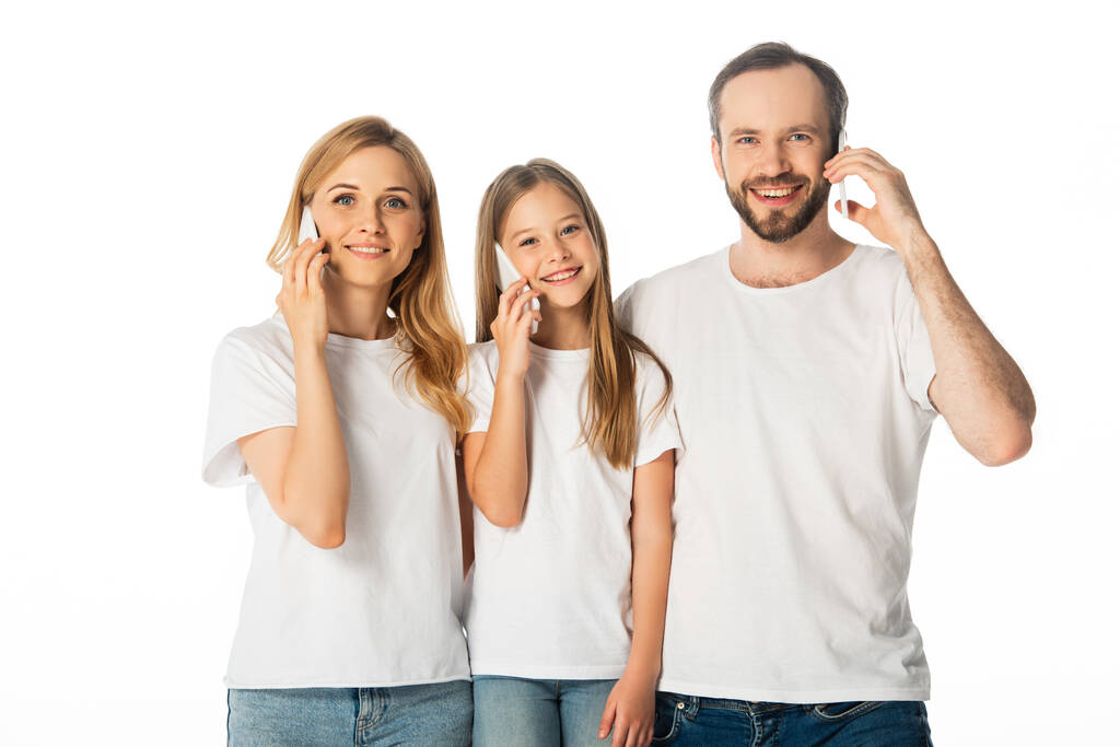 mosolygós család fehér pólóban beszél okostelefonokon elszigetelt fehér - Fotó, kép