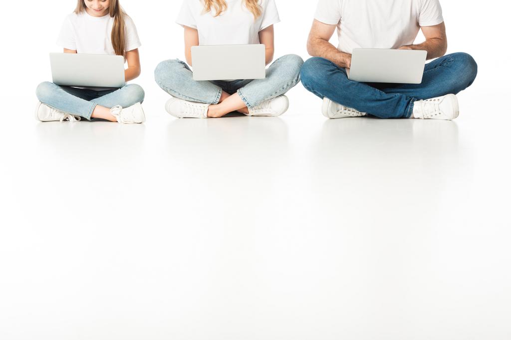 levágott kilátás család ül a padlón laptopok keresztbe lábak fehér - Fotó, kép