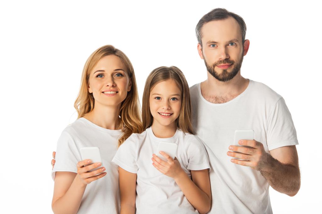 smiling family in white t-shirts using smartphones isolated on white - Photo, Image