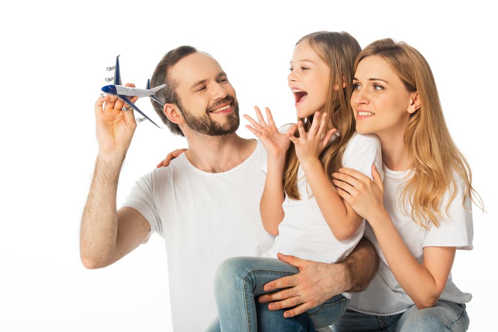 szczęśliwa uśmiechnięta rodzina z odizolowanym na biało modelem samolotu - Zdjęcie, obraz