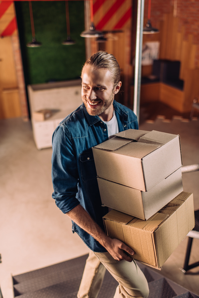 veselý podnikatel drží krabice v nové kanceláři - Fotografie, Obrázek