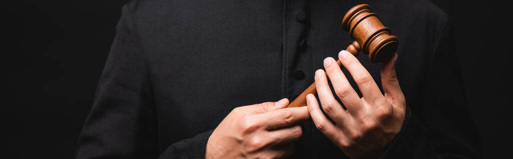 cultivo panorámico de sacerdote sosteniendo martillo de madera aislado en negro
  - Foto, imagen