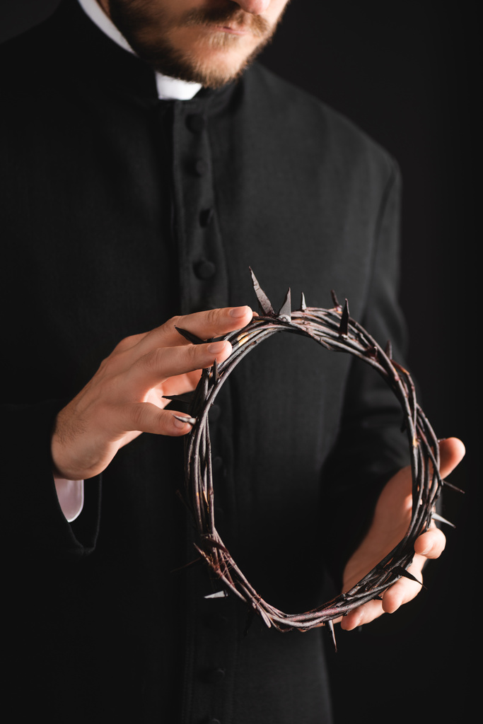 περικοπή άποψη του γενειοφόρου ιερέα κρατώντας αιχμηρό στεφάνι με αιχμές που απομονώνονται σε μαύρο  - Φωτογραφία, εικόνα