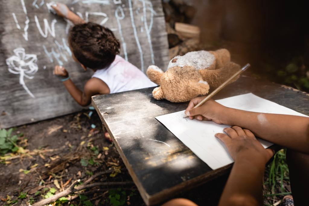částečný pohled na africké americké dítě psaní poblíž Kids and Chalkboard  - Fotografie, Obrázek