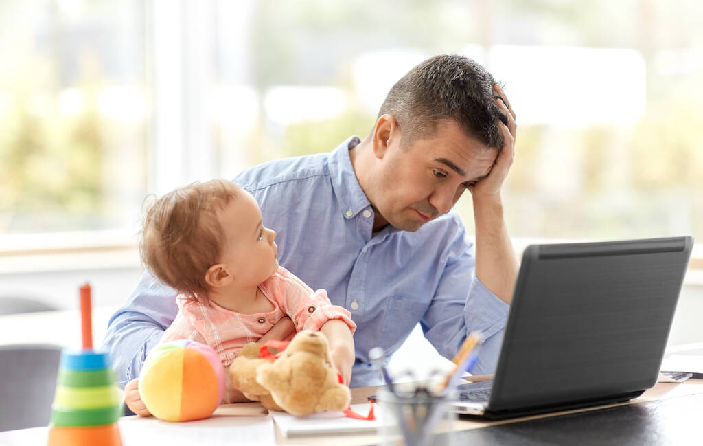 vader met baby werken op laptop thuis kantoor - Foto, afbeelding