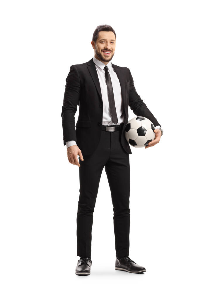 Retrato de cuerpo entero de un hombre con traje sosteniendo una pelota de fútbol y mirando a la cámara aislada sobre fondo blanco
 - Foto, Imagen
