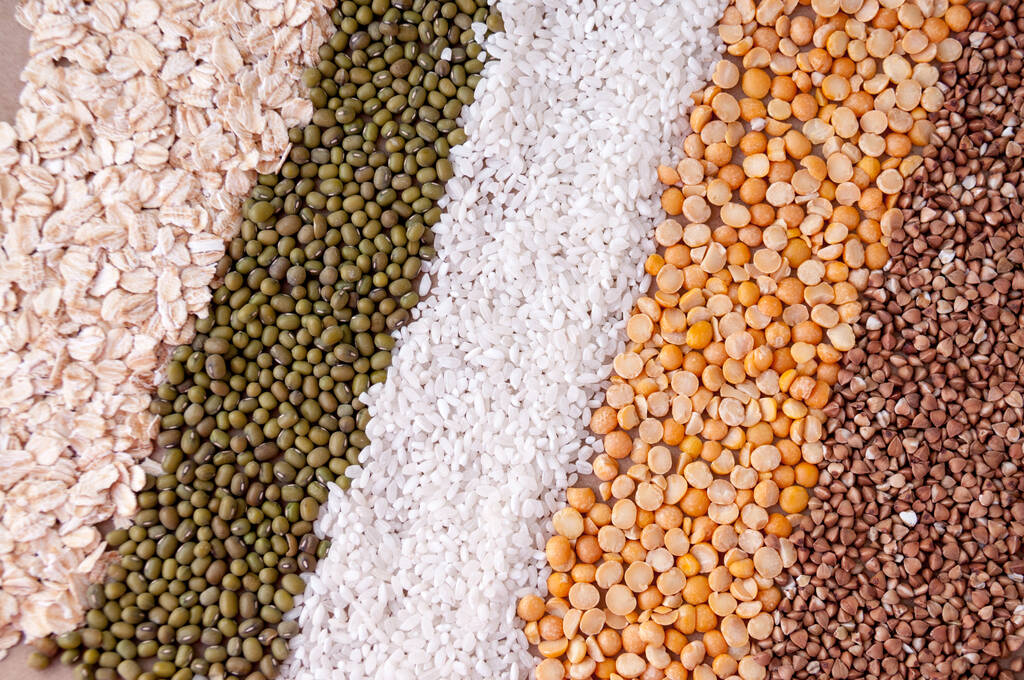 Hintergrund in einem Streifen Getreide Haferflocken, Brei, Reis, Erbsen und Buchweizen auf dem Tisch, Draufsicht - Foto, Bild