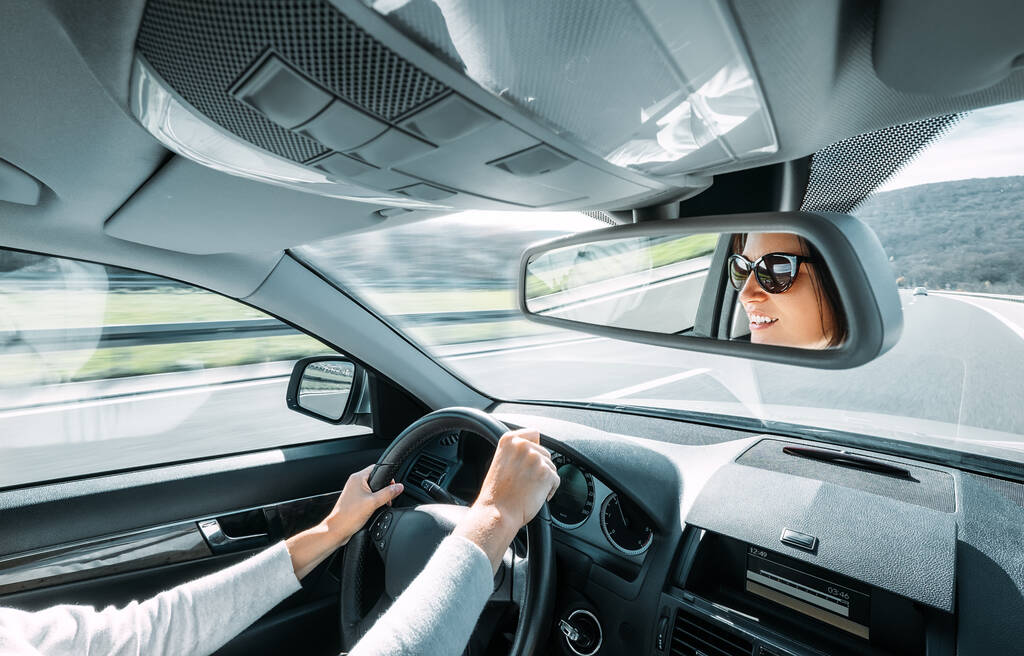 Mujer conducir un coche refleja en espejo retrovisor
 - Foto, imagen