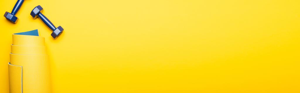 κορυφαία άποψη του έλασης στρώμα φυσικής κατάστασης και μπλε αλτήρες σε κίτρινο φόντο, πανοραμική λήψη - Φωτογραφία, εικόνα