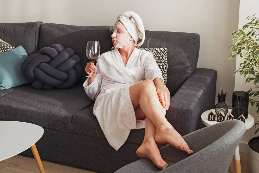 Giovane donna in accappatoio e asciugamano con bicchiere di vino rosso - Foto, immagini